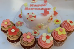 flower birthday cake and cupcakes